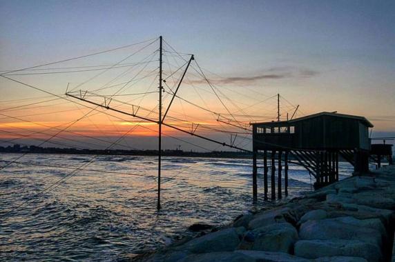 grand filet de pêche dans le barrage de Sottomarina coucher de soleil sur la mer